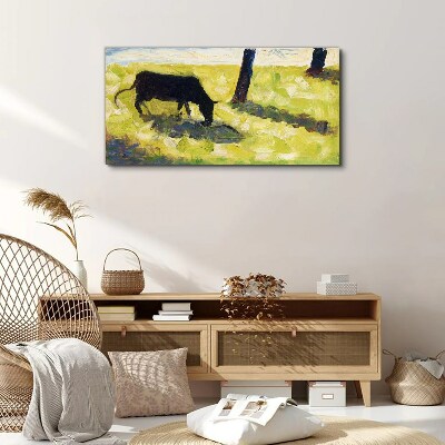 Foto auf leinwand Eine Kuh grast in einer grünen Landschaft