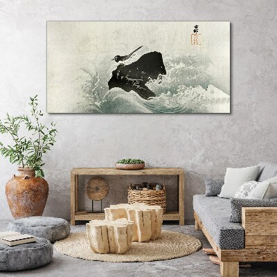 Foto auf leinwand Ein Vogel auf einem Felsen in den Wellen
