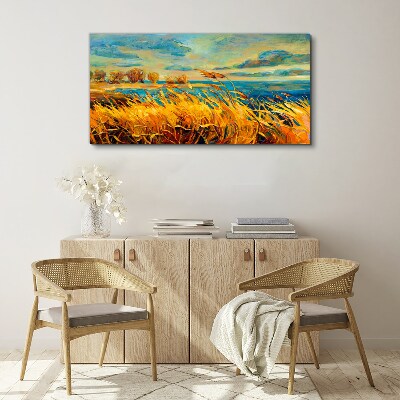Foto auf leinwand Goldenes Gras über blauem Wasser
