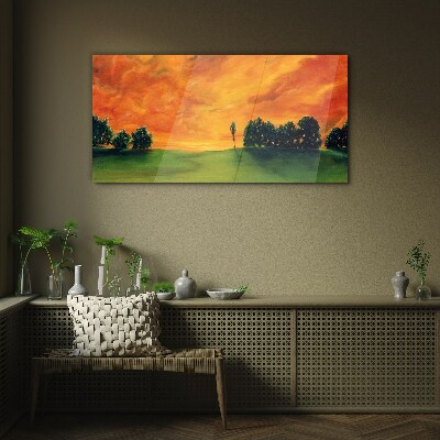 Glasbild Sonnenuntergang über dem grünen Hügel