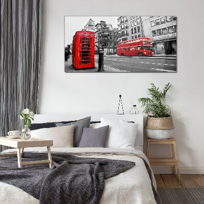 Glasbild Rotes Telefon in einer grauen Stadt