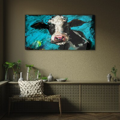 Glasbild Porträt einer Kuh auf blauem Hintergrund