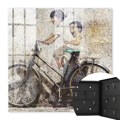 Kinder und ein Fahrrad an einer alten Mauer