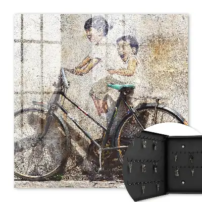 Kinder und ein Fahrrad an einer alten Mauer