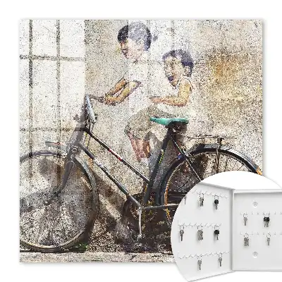 Kinder und ein Fahrrad an einer alten Mauer
